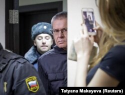 Former Economy Minister Aleksei Ulyukayev is escorted before a court hearing in Moscow on November 15.