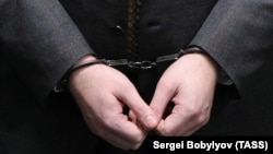 The handcuffed hands of Russian lawmaker Rauf Arashukov who was arrested this week on two counts of murder.