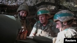 Ukrainian servicemen fire a self-propelled howitzer towards Russian troops near the frontline town of Pokrovsk