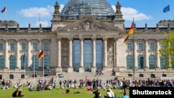 Ілюстраційне фото. Люди відпочивають на галявині перед будівлею Бундестагу