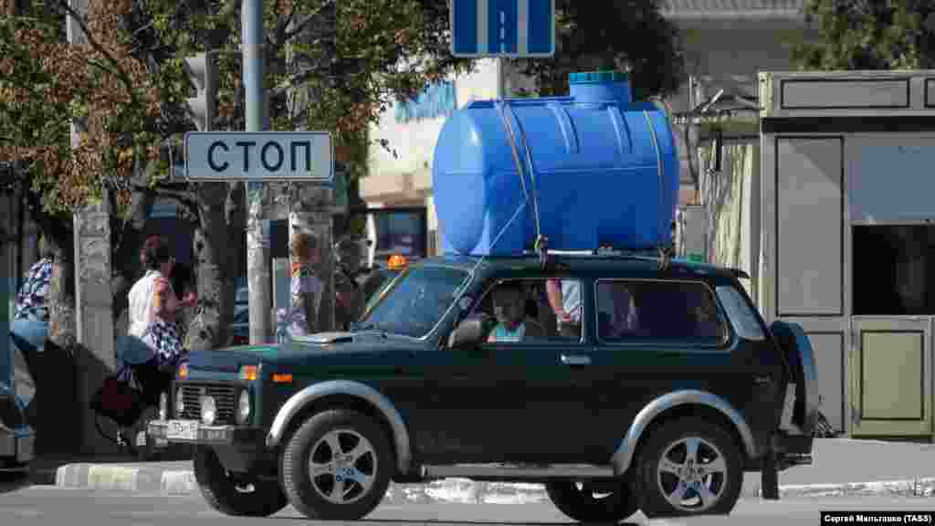 Мужчина на личном автомобиле с бочкой на крыше остановился на одной из улиц Симферополя, 24 августа 2020 года 