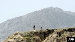 Pakistani soldiers stand guard on a mountain ridge in the tribal district of Mohmand.