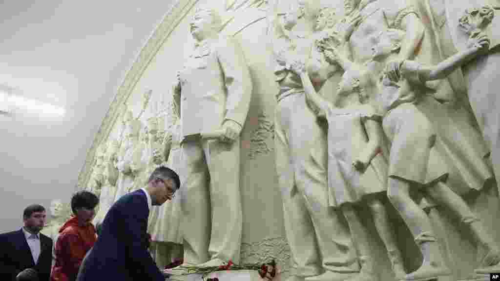 Ljudi polažu cveće ispred obnovljenog reljefa iz 1960. godine koji prikazuje sovjetskog lidera Josifa Staljina, postavljenog na stanici metroa Taganskaja u Moskvi.