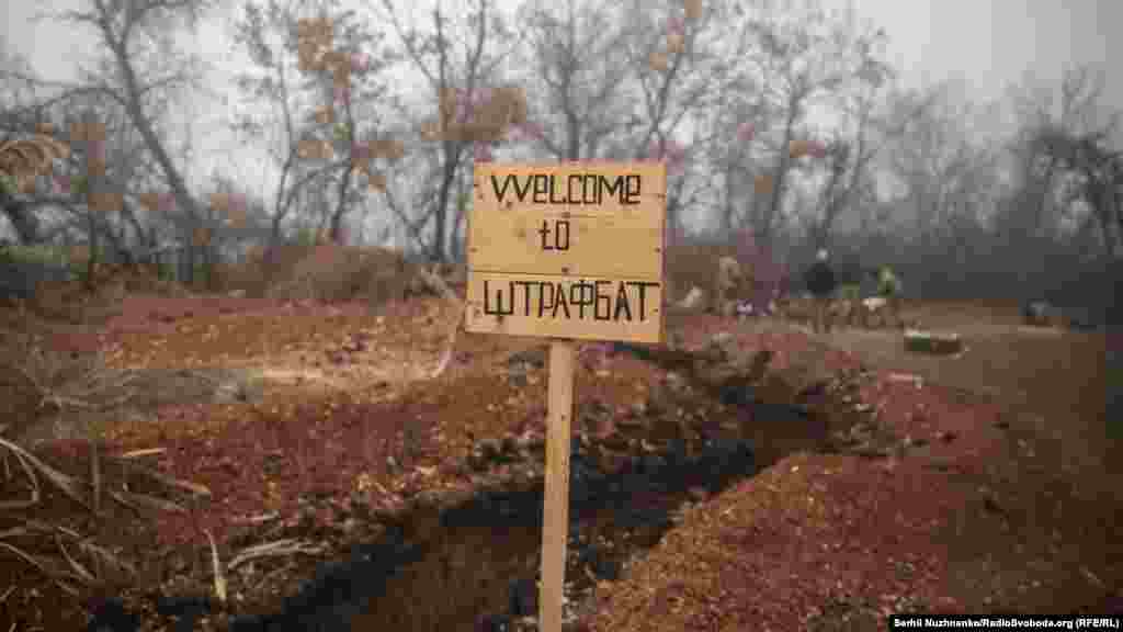 «Welcome to штрафбат» – табличка, яка нас зустрічає, звісно, жарт. Але в цьому є частка правди, адже, як каже Євген, усі, хто лише чує про те, що відправлять до нього на позиції, – одразу змінюють свою поведінку на краще. Ті, хто не усвідомили вчасно, розуміють це уже на місці