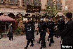 Poliția chineză patrulând străzile din Kashgar, în provincia Xinjiang.