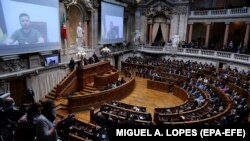 Президент України Володимир Зеленський (на екрані) під час звернення через відеозв'язок до парламенту Португалії. Лісабон, 21 квітня 2022 року