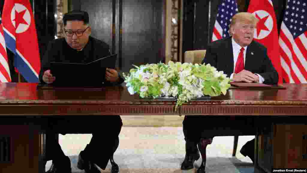 Дональд Трамп комментирует подписание документа в то время, как Ким Чен Ын рассматривает только что подписанный документ. «Сегодня у нас прошла историческая встреча, мы решили оставить прошлое позади. Мы решили подписать исторический документ. Мир увидит большое изменение», – заявил северокорейский лидер Ким Чен Ын
