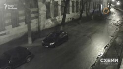 Через двадцять секунд звідти ж виходить уже знайома особа в масці і пакетом