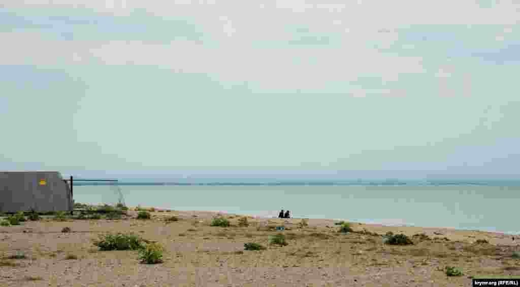 Двое на пляже у «замороженной» набережной, неподалеку от базы отдыха «Родная гавань»