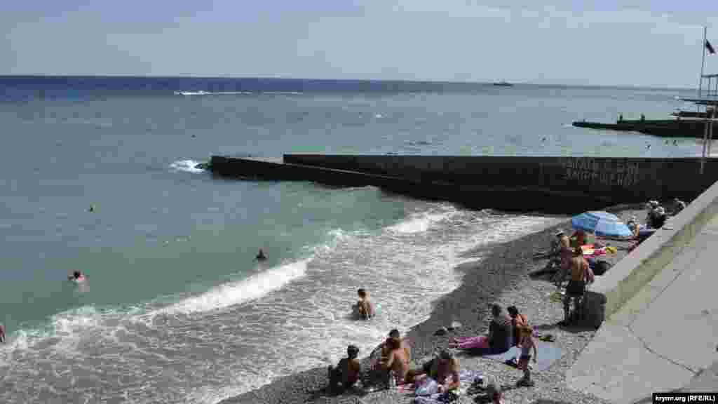 А это уже Ялта, пляж «Солнечный 2». На узкой полосе покрытого галькой берега ютятся десятки отдыхающих, социальную дистанцию они соблюдают по своему усмотрению. Организованно этот процесс там не обеспечивают, хотя на информационном стенде при входе есть памятка о коронавирусе