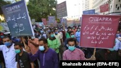 Restaurant workers shout slogans and hold placards during a protest against restrictions imposed by the authorities after indoor dining was banned following a rise in COVID-19 coronavirus cases in Karachi on December 3.