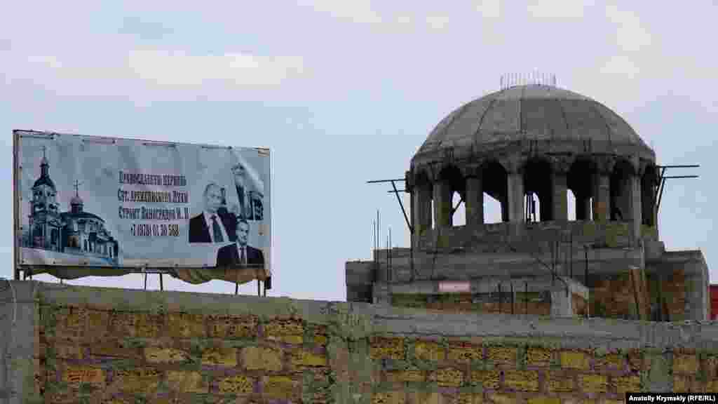 Православную церковь местный предприниматель строит уже более десяти лет. Для верности в 2014 году на информационном щите разместил портреты своих главных «покровителей»