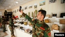 Музей ИГИЛа в Ираке. Боец курдского отряда делает селфи на фоне самодельных бомб, 12 мая 2019 г.