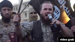 Ethnic Albanian Kosovar Lavdrim Muhaxheri (holding microphone) appears in an IS video calling on Albanian Muslims to join militants fighting against Syrian President Bashar al-Assad.