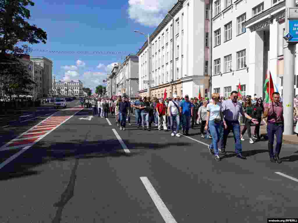 Людзі сыходзяць з плошчы ў аўтобусы. 