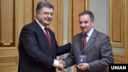 Президент України Петро Порошенко (ліворуч) вручає паспорт громадянина України Мішелю Терещенку. Київ, 21 березня 2015 року