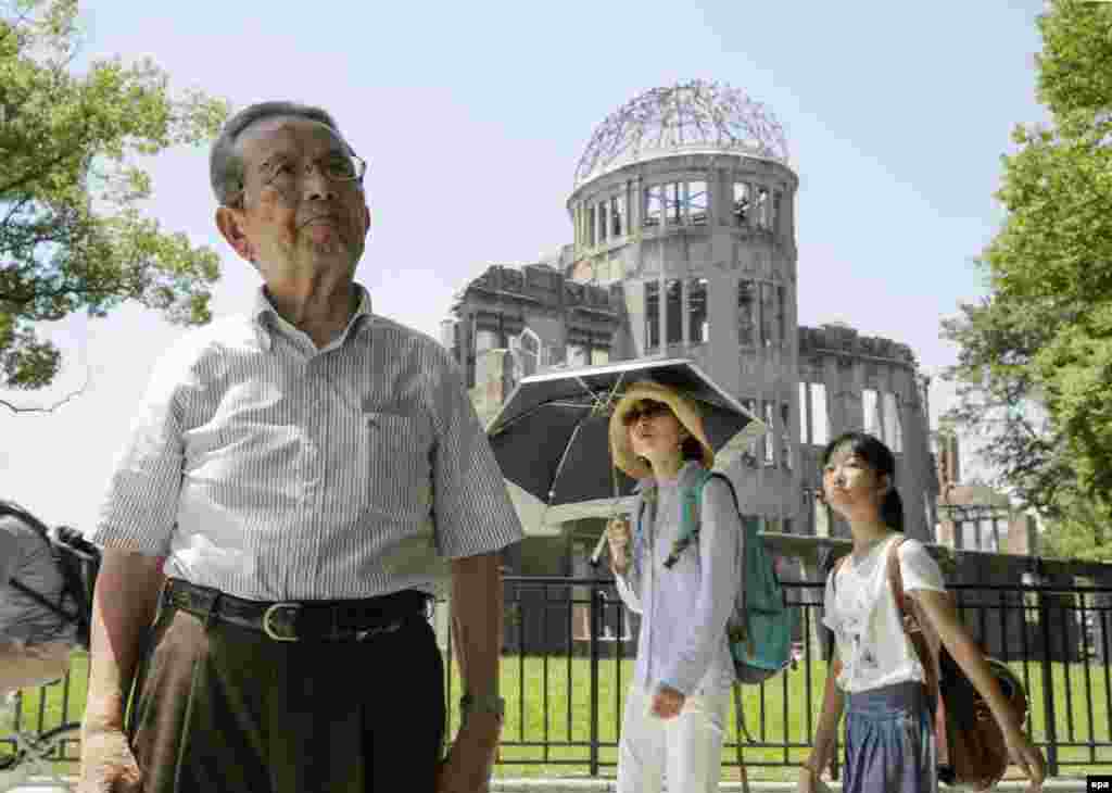 1 серпня 2015 року. 82-річний Міцуо Кодама, який вижив при бомбардуванні, стоїть поблизу «Атомного купола» – будівлі, яка до війни була Виставковим центром Торгово-промислової палати Японії. В результаті атомного бомбардування будівля була сильно пошкоджена, але вціліла, незважаючи на те, що знаходилася всього в 160 метрах від епіцентру вибуху