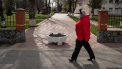 Жінка у медичній масці проходить повз закритого обмежувальною стрічкою входу до Калинівської лікарні