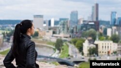 Молодая женщина стоит у башни Гедиминаса в Вильнюсе. Иллюстративное фото