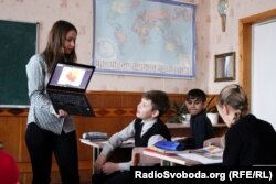 Вчителька географії показує школярам внутрішню будову Землі