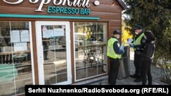 Працівники поліції складають протокол про порушення роботи кав'ярні під час карантину,в ботанічному саду імені Олександра Фоміна. Київ 4 квітня 2020 р.