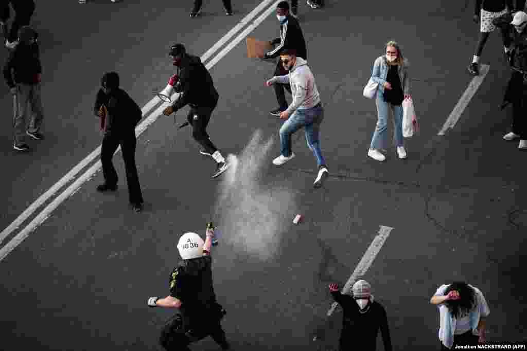 Поліція використовує перцевий спрей проти протестувальників під час демонстрації Black Lives Matter у Стокгольмі. Протест виник на знак солідарності з протестами, що вирують у США через смерть афроамериканця Джорджа Флойда. Колишнього поліцейського штату Міннеаполіс Дерека Чавіна, який став коліном на шию Джорджа Флойда під час його затримання, тепер звинувачують у вбивстві другого ступеня, а трьох його колег у допомозі та підтримці вбивства другого ступеня. Стокгольм, Швеція. 3 червня 2020 року (Фото Jonathan NACKSTRAND / AFP)