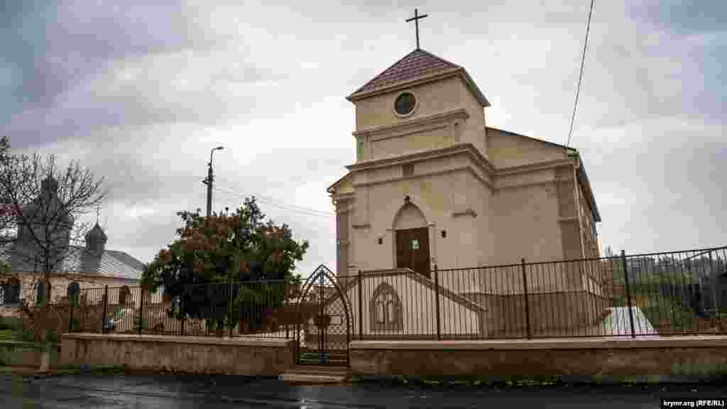 В нескольких метрах от него на той же улице – бывшая лютеранская кирха. Теперь это римско-католический костел Успения пресвятой Девы Марии местной католической общины. Еженедельно в нем проводят богослужения священники из Севастополя