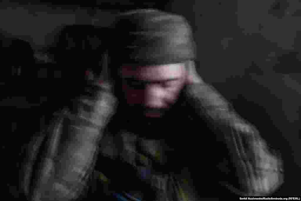 Часів Яр, травень 2023 року. Військовий ЗСУ Володимир молиться, закривши вуха, під час обстрілу українських позицій російськими військами. Кореспондент Радіо Свобода згадує, що під час цього обстрілу з РСЗВ «усе здригалося, і здавалося, що небо от-от обвалиться на голову»