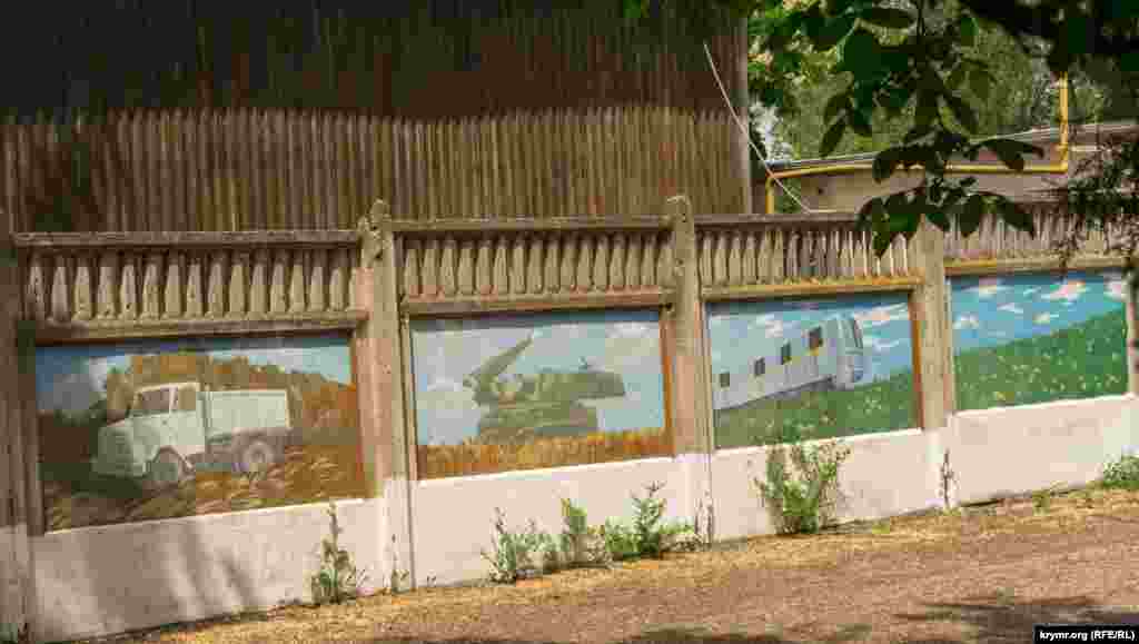 Изображения самосвала, зенитно-ракетного комплекса и вагонов метро на бетонном заборе у главных ворот детского лагеря «Бригантина» появились не случайно. Похоже, это наглядная иллюстрация того, что производит предприятие из подмосковных Мытищ «Метровагонмаш». На официальном сайте предприятия указано, что дети сотрудников могут получить путевки на отдых в Песчаном