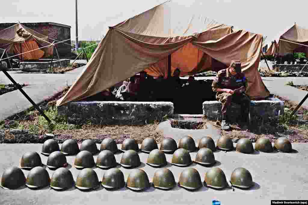 Каски, викладені акуратними рядами, на миротворчій базі неподалік від Цхінвалі в липні 1992 року.  Наступник Гамсахурдії – Едуард Шеварднадзе – підписав угоду про припинення вогню з південними осетинами в червні 1992 року. Незабаром після цього на території Південної Осетії були розгорнуті миротворчі сили, до яких увійшли грузинські, осетинські і російські військові. Угода поклала край бойовим діям, в результаті яких, за деякими оцінками, загинуло близько 1000 осіб, але не вирішила більш широкого питання про статус Південної Осетії