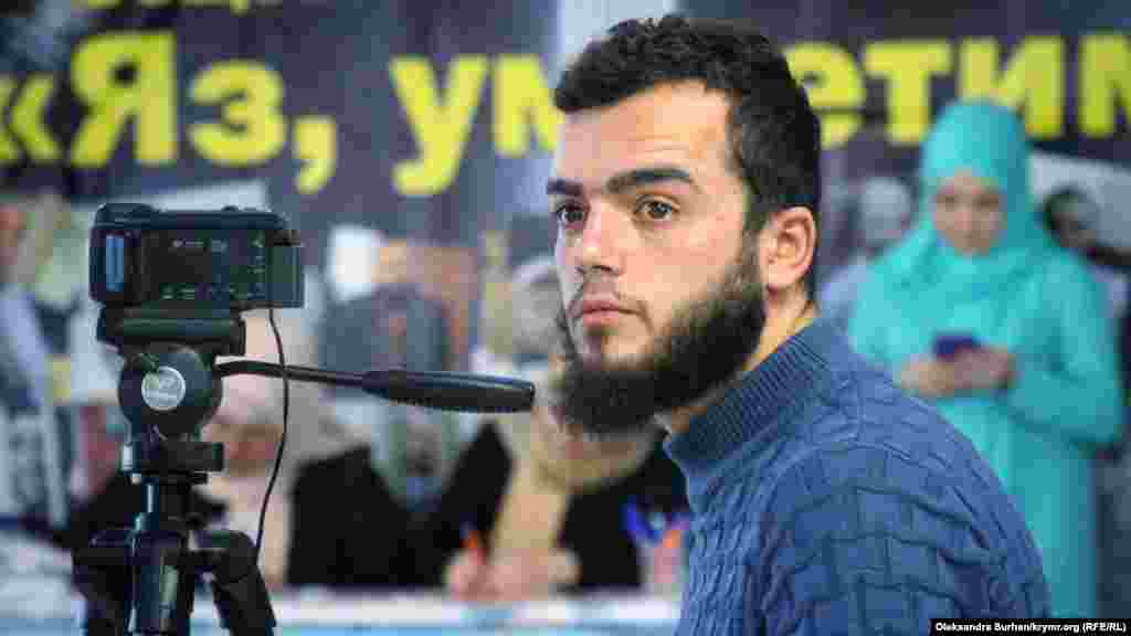 Один из гражданских журналистов «Крымской солидарности» Сейдамет Мустафаев слушает Лилю Гемеджи и снимает ее выступление на видео