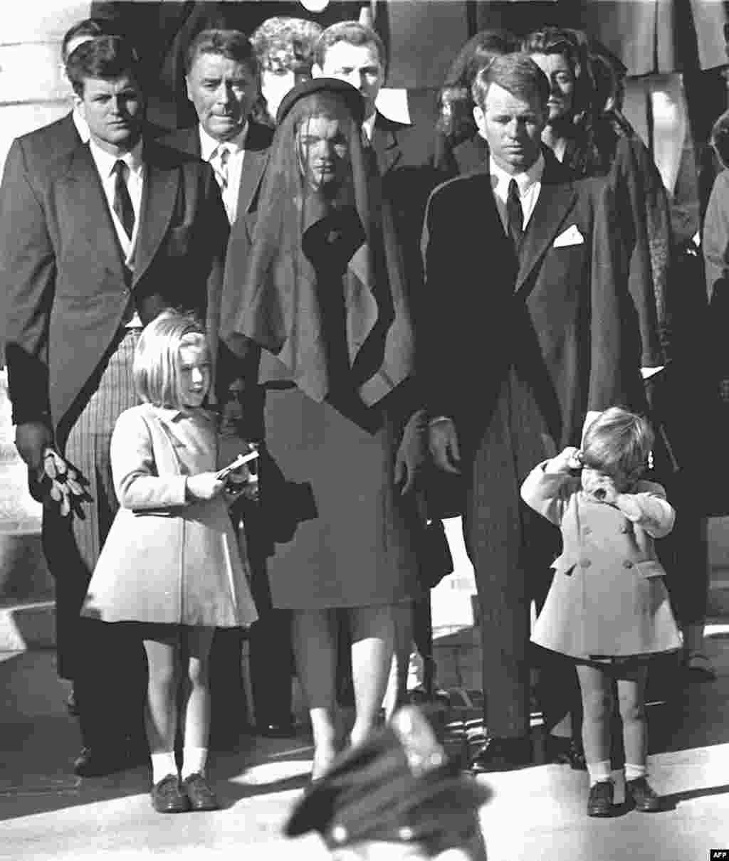 Jacqueline Kennedy stands with her two children, Caroline and John Jr., and brothers-in law Edward (Ted) (back left) and Robert (back right) at President Kennedy's funeral on November 26, 1963, in Washington, D.C.