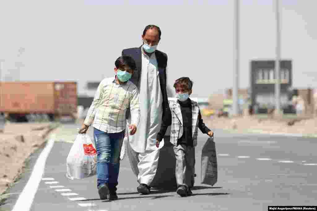 Afghans walk at the Dowqarun border crossing on August 29.