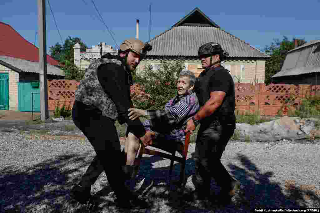 Серпень 2024 року. Літню жінку, яка не може самостійно пересуватися, евакуюють з Новогродівки. Російські війська окупують місто через 20 днів після цього фото. Чоловік праворуч – 53-річний волонтер Оуен із Нової Зеландії. У минулому він – бойовий медик, приїхав в Україну допомагати із порятунком людей