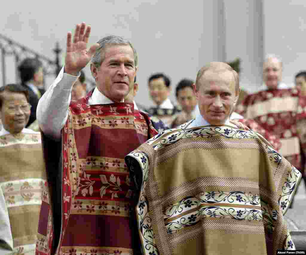 Putin și Bush (junior) poartă poncho-uri chiliene la o sesiune oficială de fotografii a liderilor APEC pe 21 noiembrie 2004. Locul este palatul La Moneda din Santiago, locul unde a murit, după o lovitură de stat sprijinită de SUA, președintele marxist Salvador Allende, în 1973.