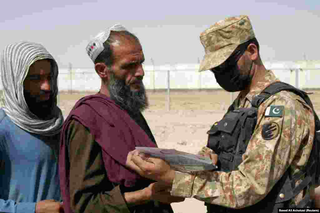 A Pakistani soldier checks documents of people arriving from Afghanistan at the Friendship Gate crossing point in Chaman on August 27.