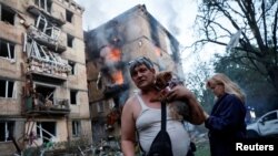 კიევზე რუსეთის ჯარების მასირებული შეტევის შედეგად განადგურებული სახლი და მისი გადარჩენილი მობინადრეები. 2025 წლის 17 ივნისი