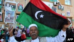 A Libyan man holds his new national flag aloft during celebrations in the eastern coastal city of Benghazi.