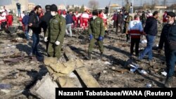 Security officers and Red Crescent workers inspect the site where the Ukraine International Airlines Flight PS752 crashed after takeoff from Iran's Imam Khomeini Airport on the outskirts of Tehran on January 8, 2020.