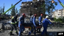 Рятувальники несуть тіло загиблого через російський удар по Києву вночі проти 28 серпня 2025 року