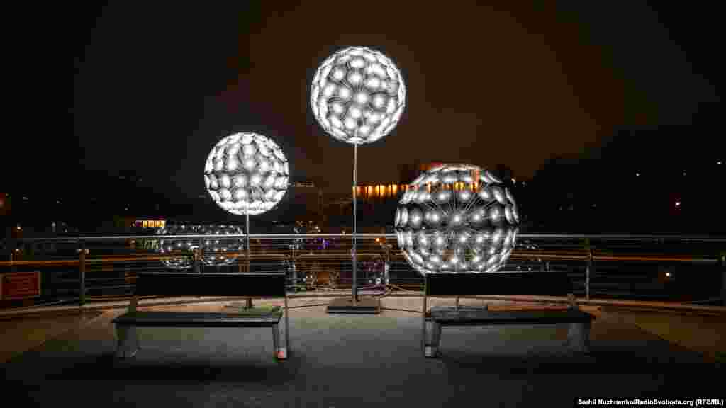Пішохідно-велосипедний міст. Одну із зупинок маршруту – пішохідно-велосипедний міст над Володимирським узвозом – прикрасили інсталяцією у вигляді куль, що світяться