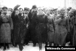 Парад, про який писав Булгаков у «Білій гвардії»: керівники Директорії УНР Володимир Винниченко (знімає капелюха) і Симон Петлюра (з піднятою рукою) на Софіївській площі в Києві, 19 грудня 1918 року