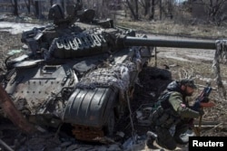 Проросійський бойовик біля підбитого українського танка у селищі Спартак, березень 2015 року