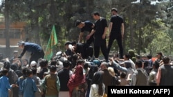 Internally displaced Afghans gather to receive food being distributed by a local charity in Kabul on August 13.