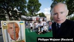 جرمني: په برلن کې د روسیې سفارت مخې ته یوه کس د روسي ولسمشر پوتین مول وهلی چې د بیان ازادۍ لپاره د ۲۰۱۸ کال پر ۱۲م جون راوتلي ول.