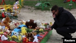 Цветы и игрушки на детской площадке в Кривом Роге, где в результате российского удара 4 апреля погибли, в частности, девять детей