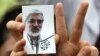 Іран - Прихильник кандидата у президенти Міра Хосейна Мусаві, тримає його зображення під час передвиборного мітингу на стадіоні у Тегерані, 9 червня 2009 р.