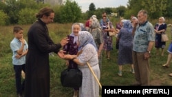 Отец Роман с прихожанами на месте, где будет заложен каменный фундамент храма Ксении Петербургской