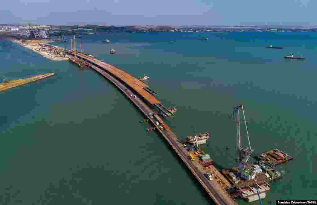 Вид с высоты показывает конец моста со стороны Крыма. Фотограф Станислав Забурдаев, который сделал этот снимок при помощи дрона в июле 2017 года, сказал Радио Свободе, что темпы строительства очевидны: «Я был там и в прошлом году. Впереди еще много работы, долгий путь, но за прошлый год было очень много сделано. Я на самом деле был поражен».