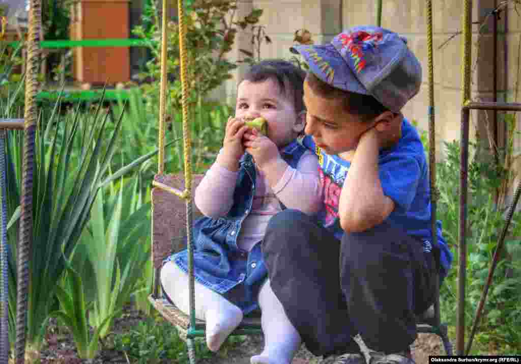 Наджие и Юнус, дети крымскотатарского правозащитника Сервера Мустафаева, катаются на качелях. Южный окружной военный суд в российском Ростове-на-Дону приговорил Сервера Мустафаева к 14 годам колонии строгого режима по «делу Хизб ут-Тахрир». Его мать Венера Мустафаева накануне приговора выходила на одиночный пикет в поддержку сына с плакатом «Разговоры в мечети – не преступление! Верните мне сына», за что была оштрафована